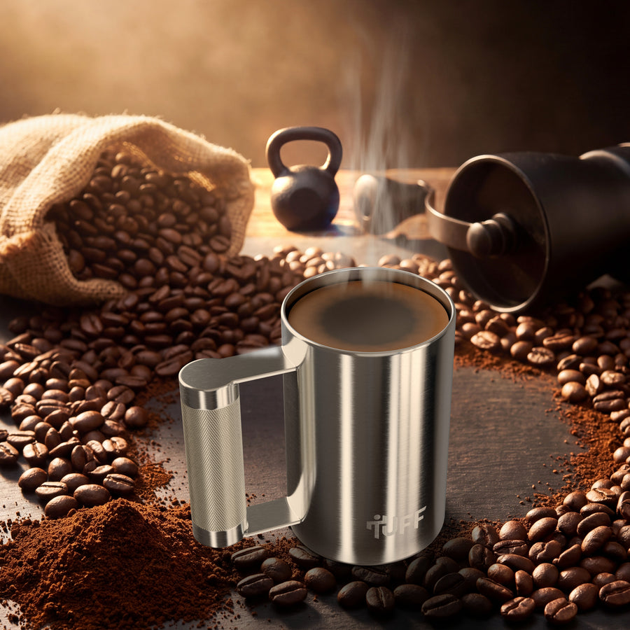 The Tuff Mug full of hot coffee, ringed by coffee beans