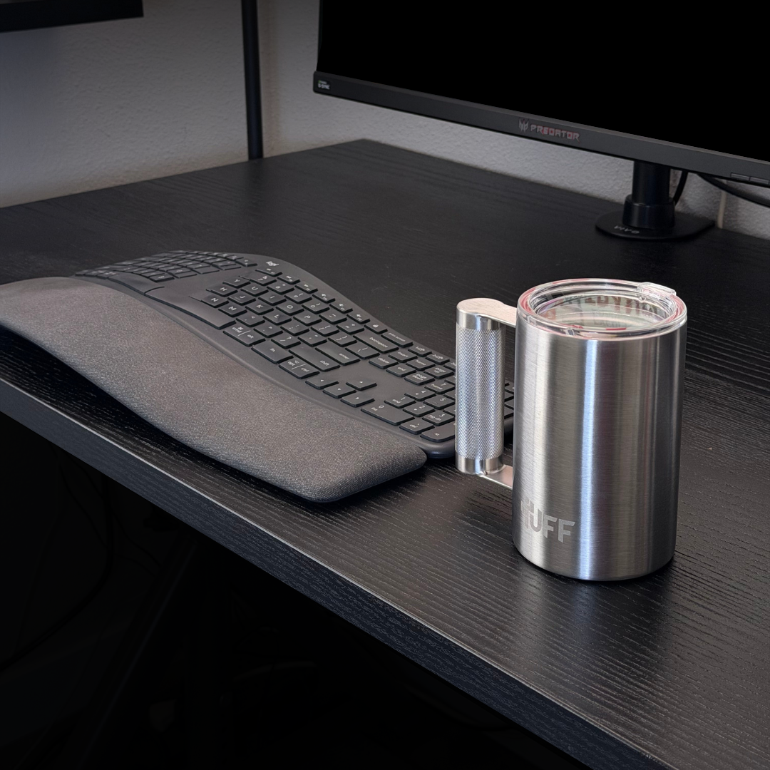 Stainless 16oz Tuff Mug with barbell-style handle on a desk next to a keyboard