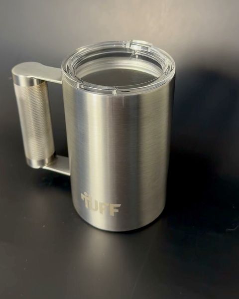 The clear press-in lid seated on the silver mug.